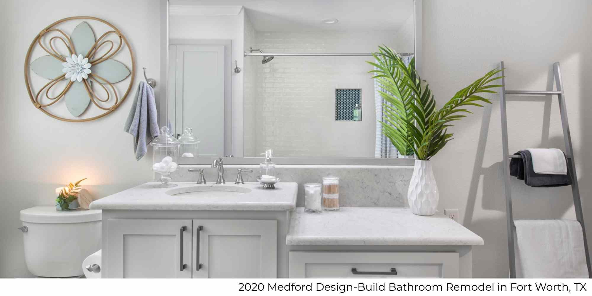 A remodeled bathroom in a whole home remodel with a large mirror and custom vanity by Medford Design-Build in Fort Worth, TX