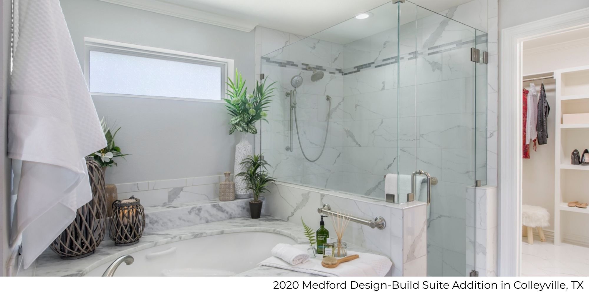 Bathroom in a suite addition featuring a large glass shower, soaking tub with a stone surround, and a doorway to a walk-in closet by Medford Design-Build in Colleyville, TX