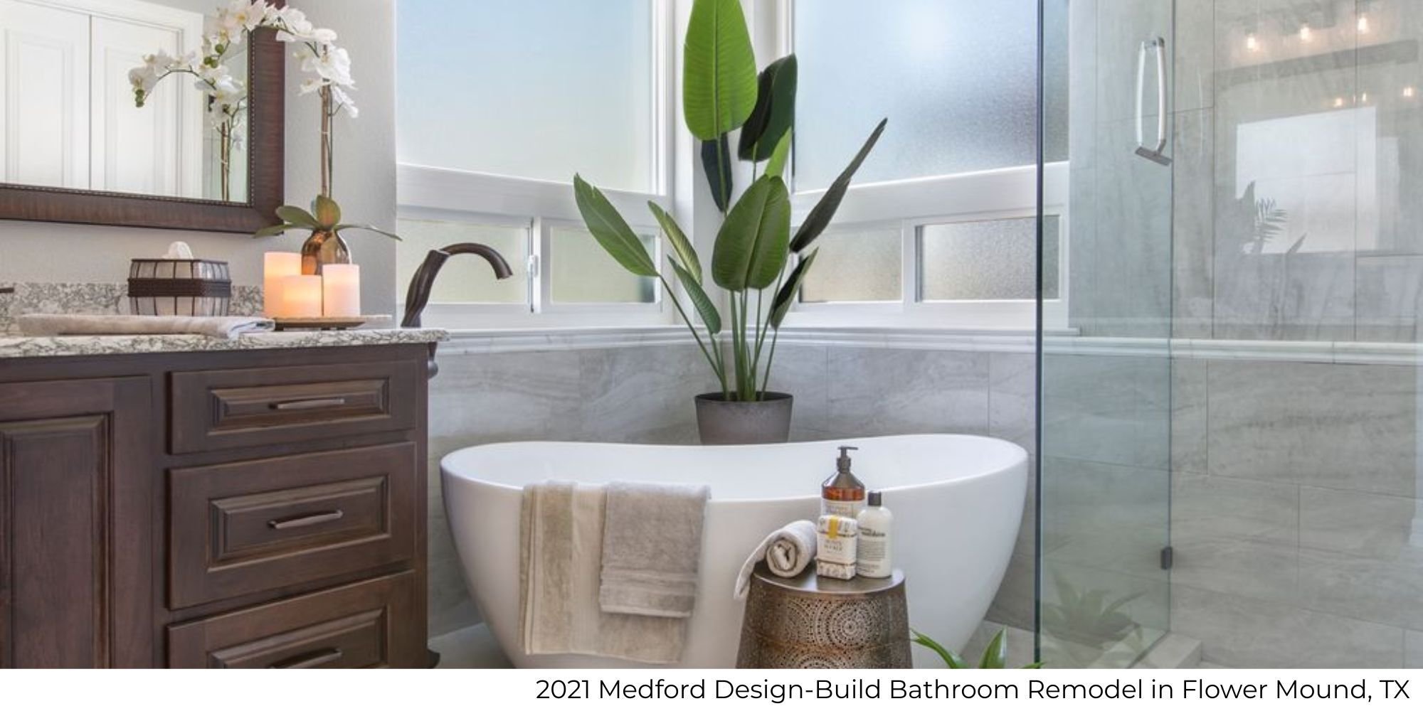Bathroom remodel featuring a standalone soaking tub, large frameless glass shower, and natural wood vanity by Medford Design-Build in Flower Mound, TX