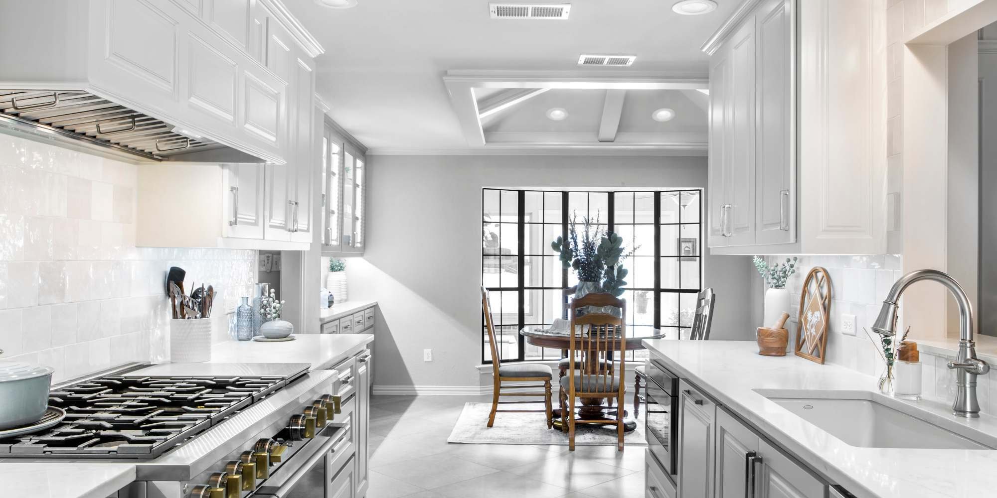 Modern white kitchen with gas range and natural light in Arlington renovation by Medford Design-Build