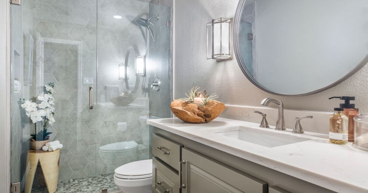 Sleek Arlington bathroom with round mirror, quartz countertop, and walk-in shower by Medford Design-Build Sleek Arlington bathroom with round mirror, quartz countertop, and walk-in shower by Medford Design-Build